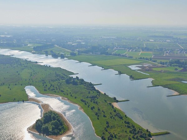 Luchtfoto van rivier met kribben en ondergelopen uiterwaarden